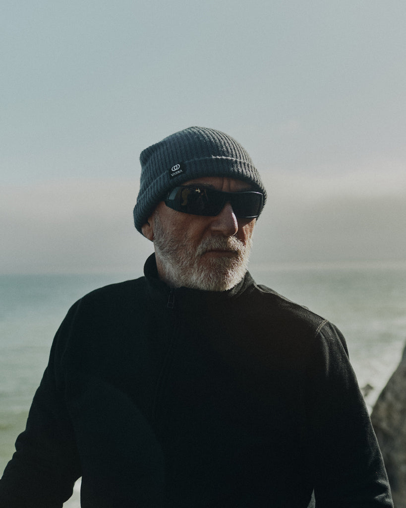 Ralph Dunning standing on a cliff that overlooks the Pacific ocean wearing the Foreign Rider Quarter Zip Sweatshirt