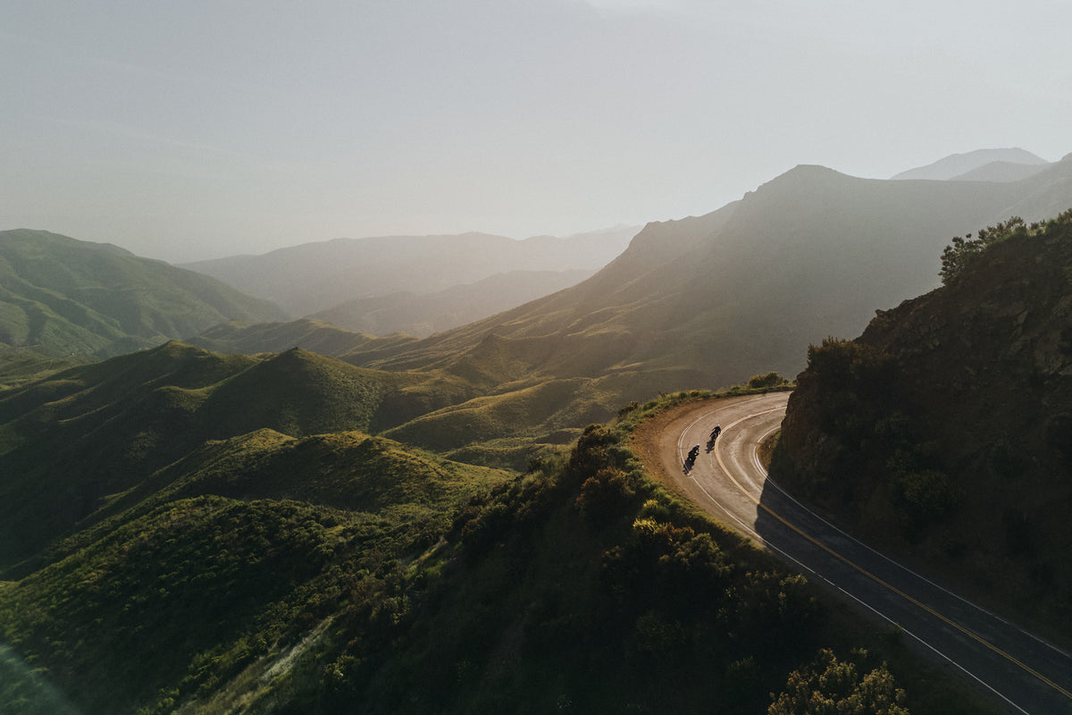 Landscape image of Malibu Nature and 2 men riding motorcycles