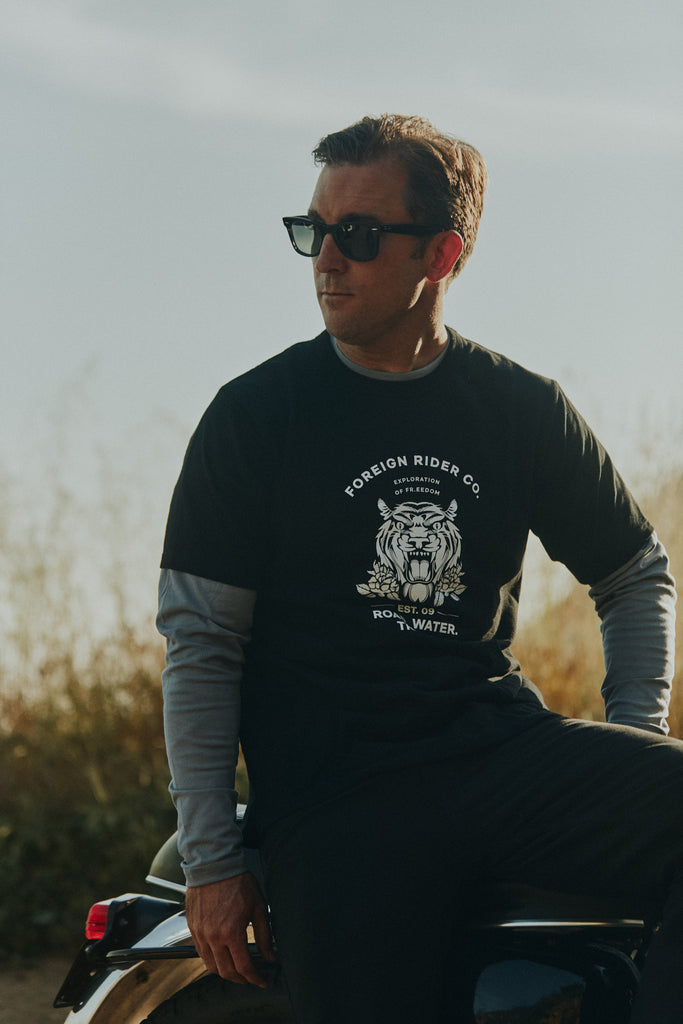 Man sitting on a vintage motorbike wearing the Foreign Rider Tiger Graphic T-Shirt