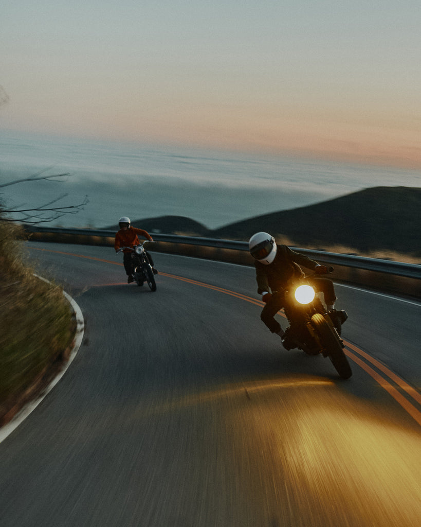2 men riding motorbikes on the Pacific Coast Highway wearing the Foreign Rider Co Waxed Canvas Utility Jacket
