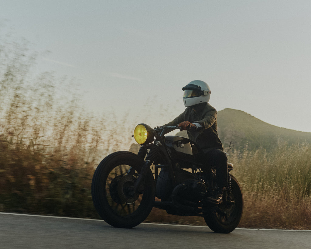 Man riding BMW motorbike on the Pacific Coast Highway wearing Foreign Rider Co Waxed Canvas Utility Jacket