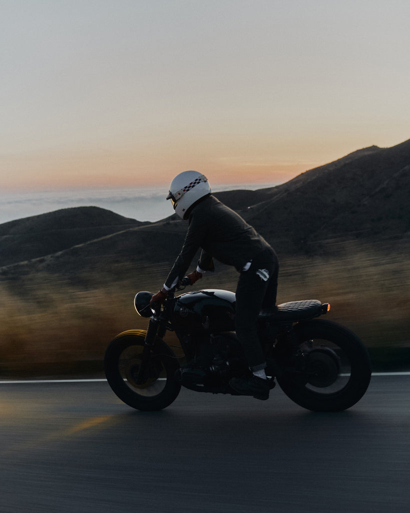 Man riding motorbike on the Pacific Coast Highway wearing Foreign Rider Co Waxed Canvas Utility Jacket