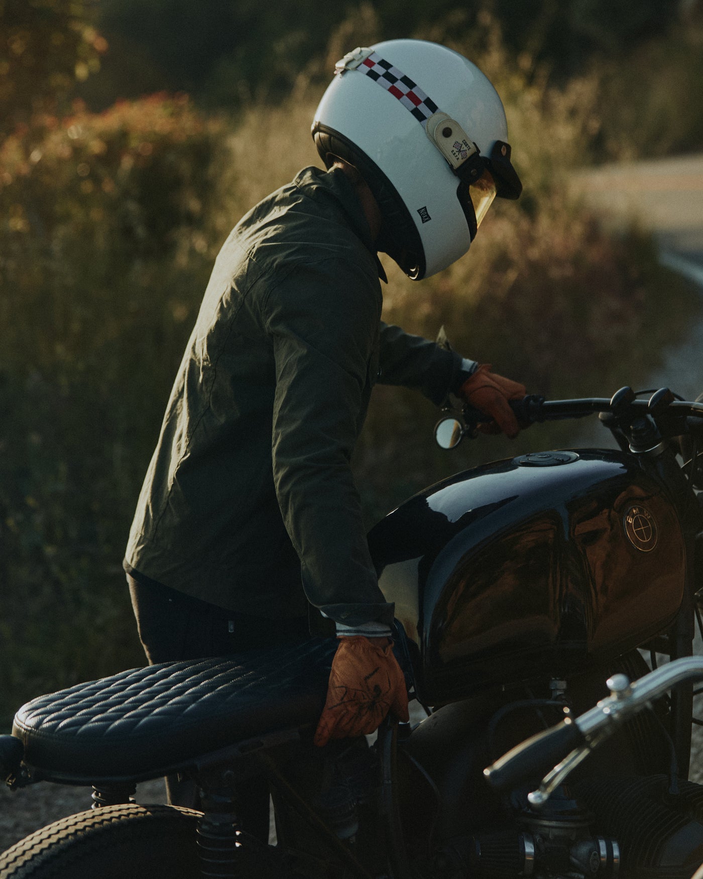 Man pushing BMW motorbike onto Pacific Coast Highway wearing the Foreign Rider Co Waxed Canvas Utility Jacket