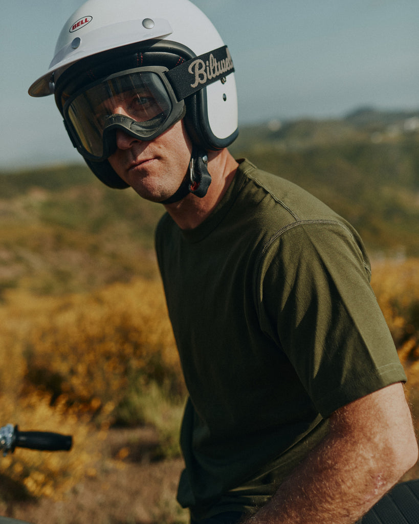 Man sitting on idle motorbike wearing Bell Helmet and Biltwell goggles wearing Foreign Rider Supima Cotton Short Sleeve T-shirt