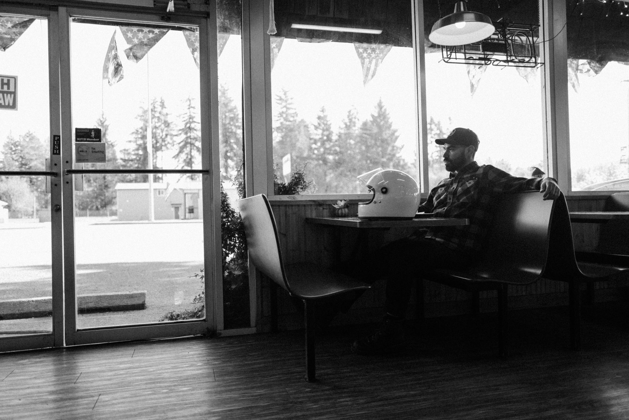 Man sitting inside at Sully's Drive-In wearing Foreign Rider Co Flannel
