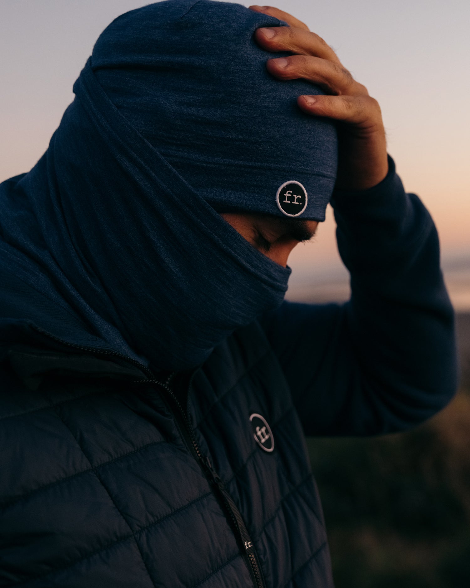 Man looking down with left hand resting and shift Foreign Rider co Merino Beanie