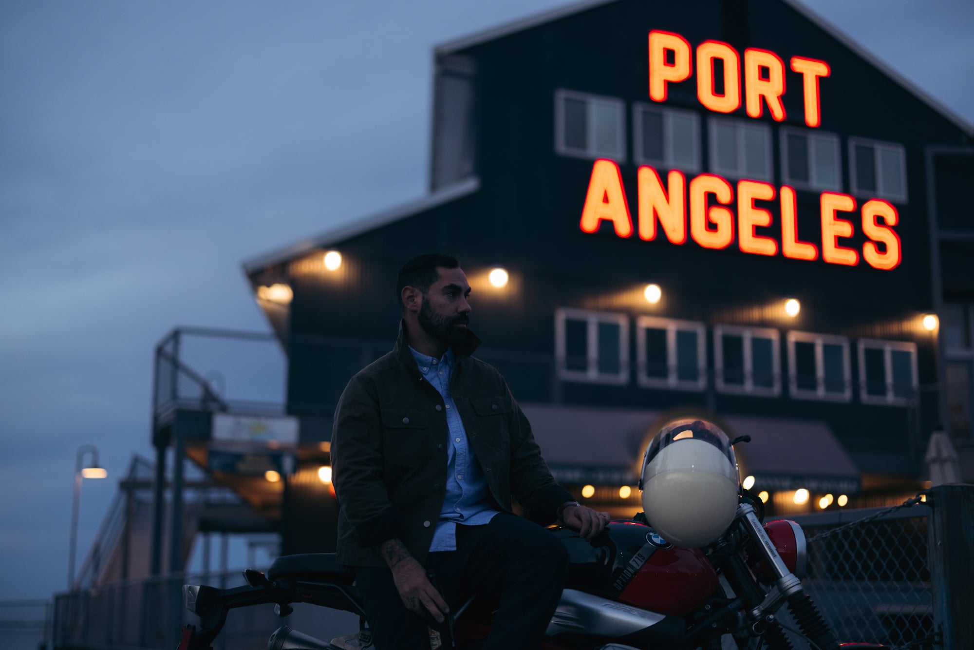 Man sitting on the side of BMW motorbike at the Port Angeles Wharf