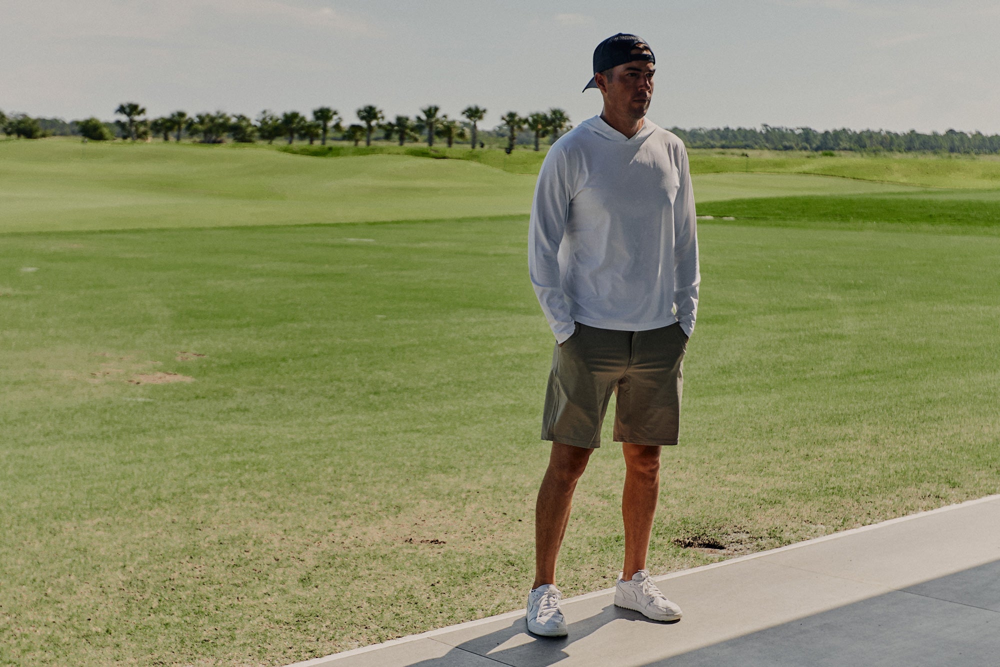 Man at Grove XXIII golf course wearing Foreign Rider Performance Hooded Long Sleeve T-shirt
