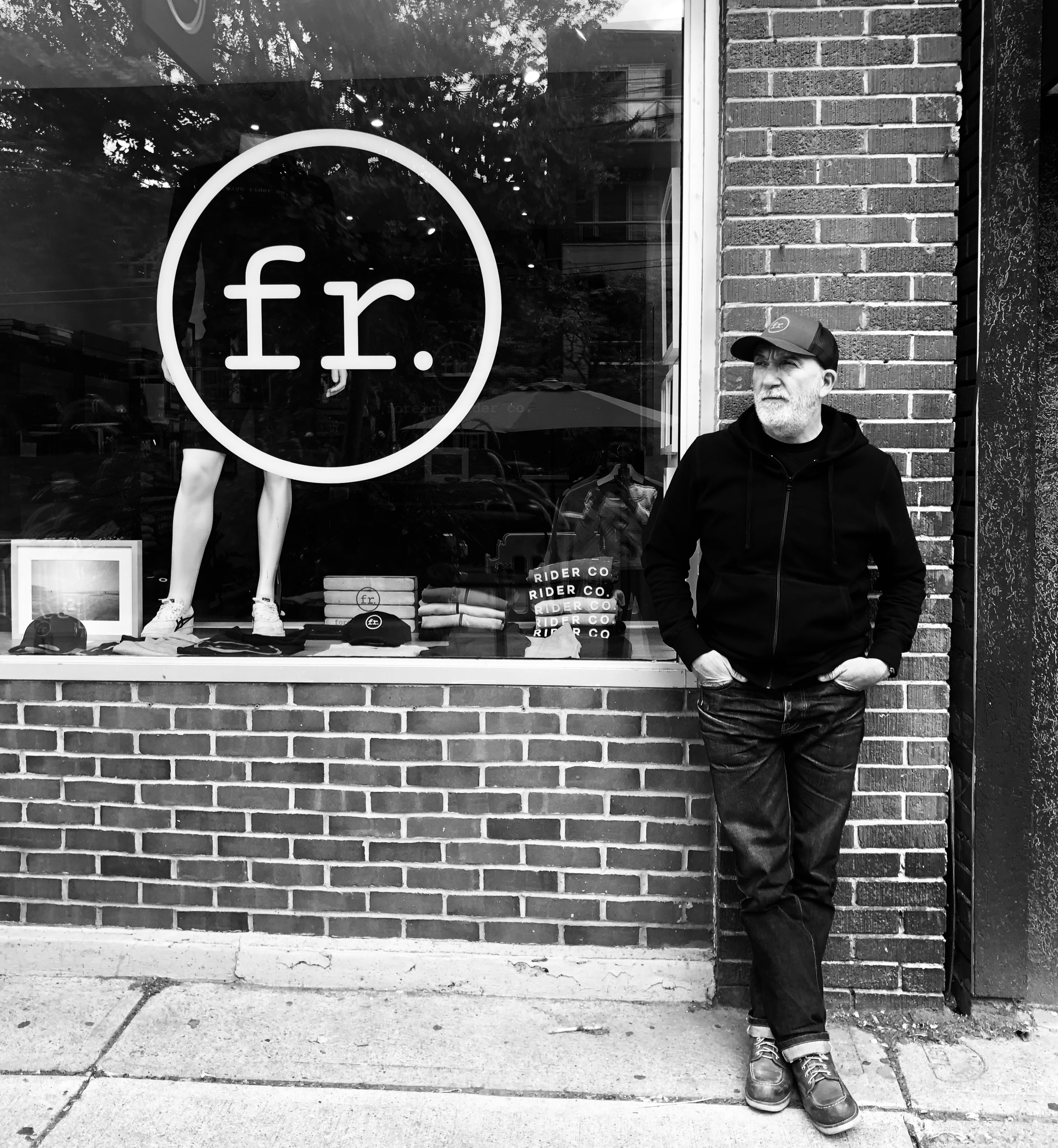 Founder Ralph Dunning leaning on the storefront of Foreign Rider Co. Toronto location
