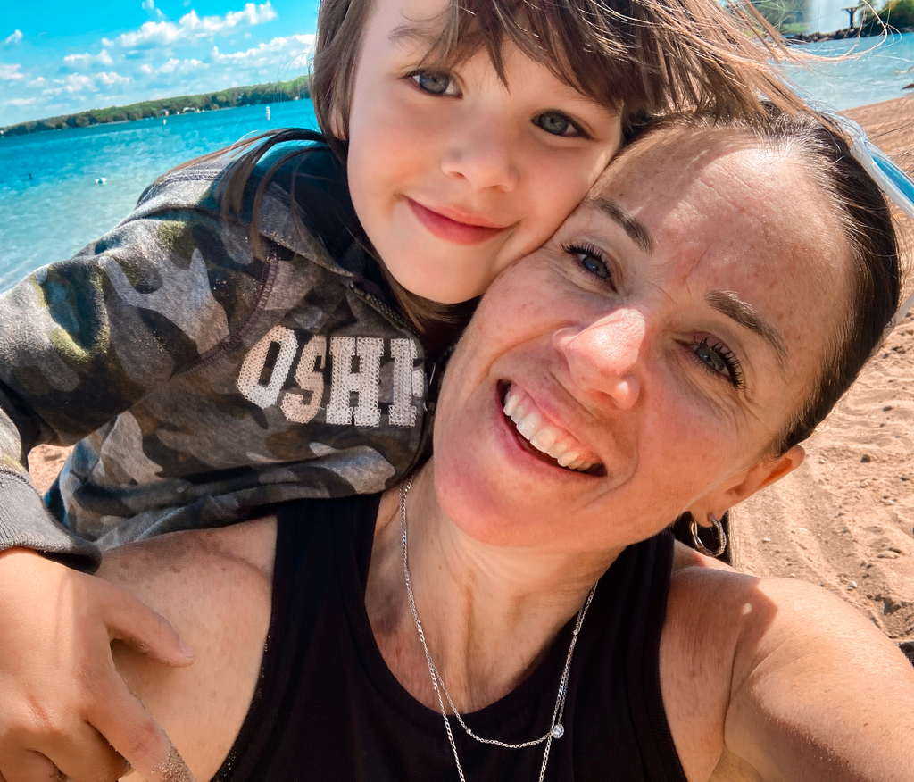Closeup photo of Shannon Kemp and her child on beach