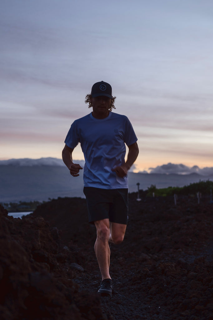 Eric Lagerstrom running on lava rocks at sunset wearing Foreign Rider FR. Performance Short Sleeve T-Shirt