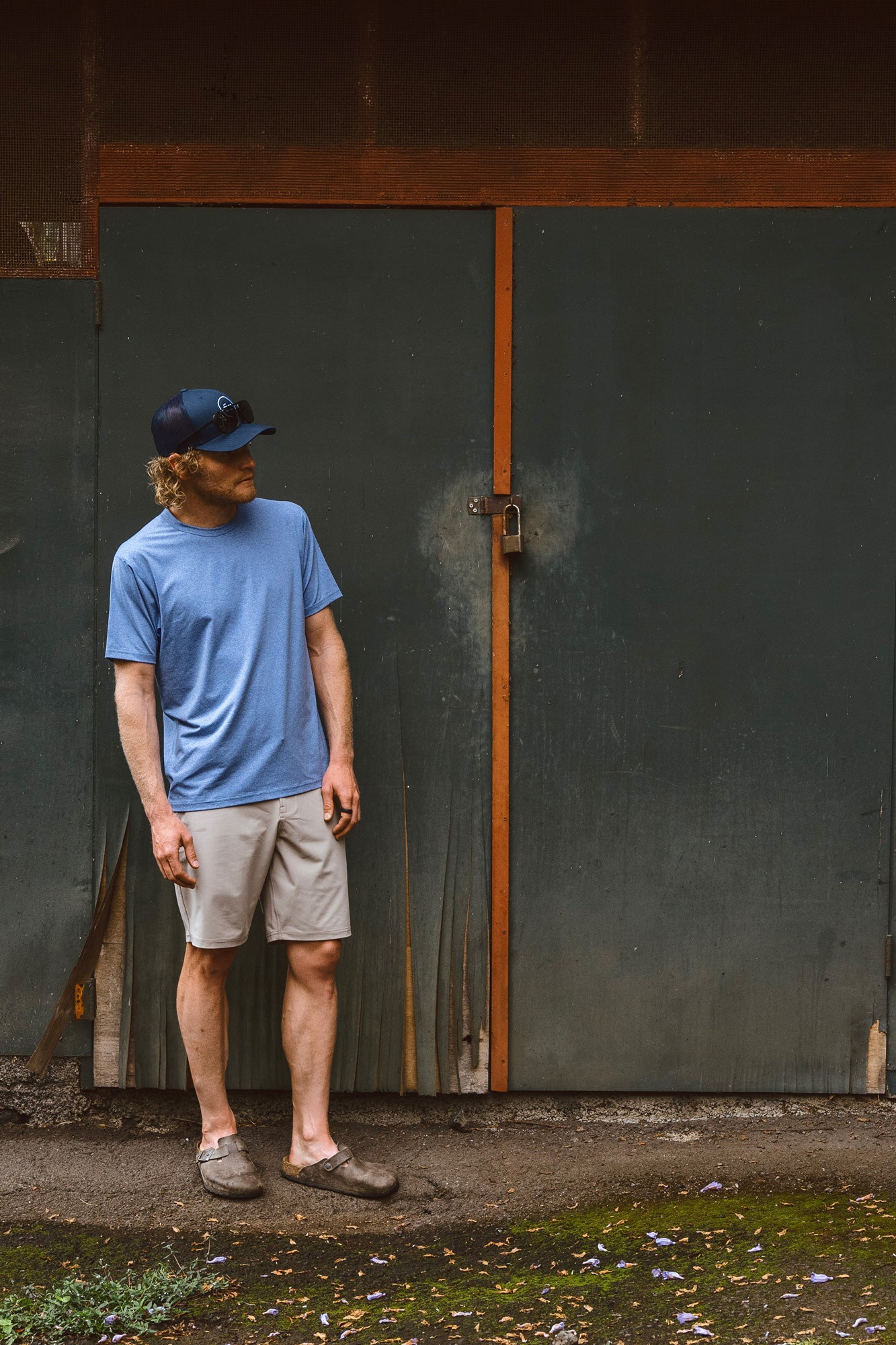 Eric Lagerstrom standing outdoors in front of a rundown wall wearing Foreign Rider Performance Short Sleeve T-shirt