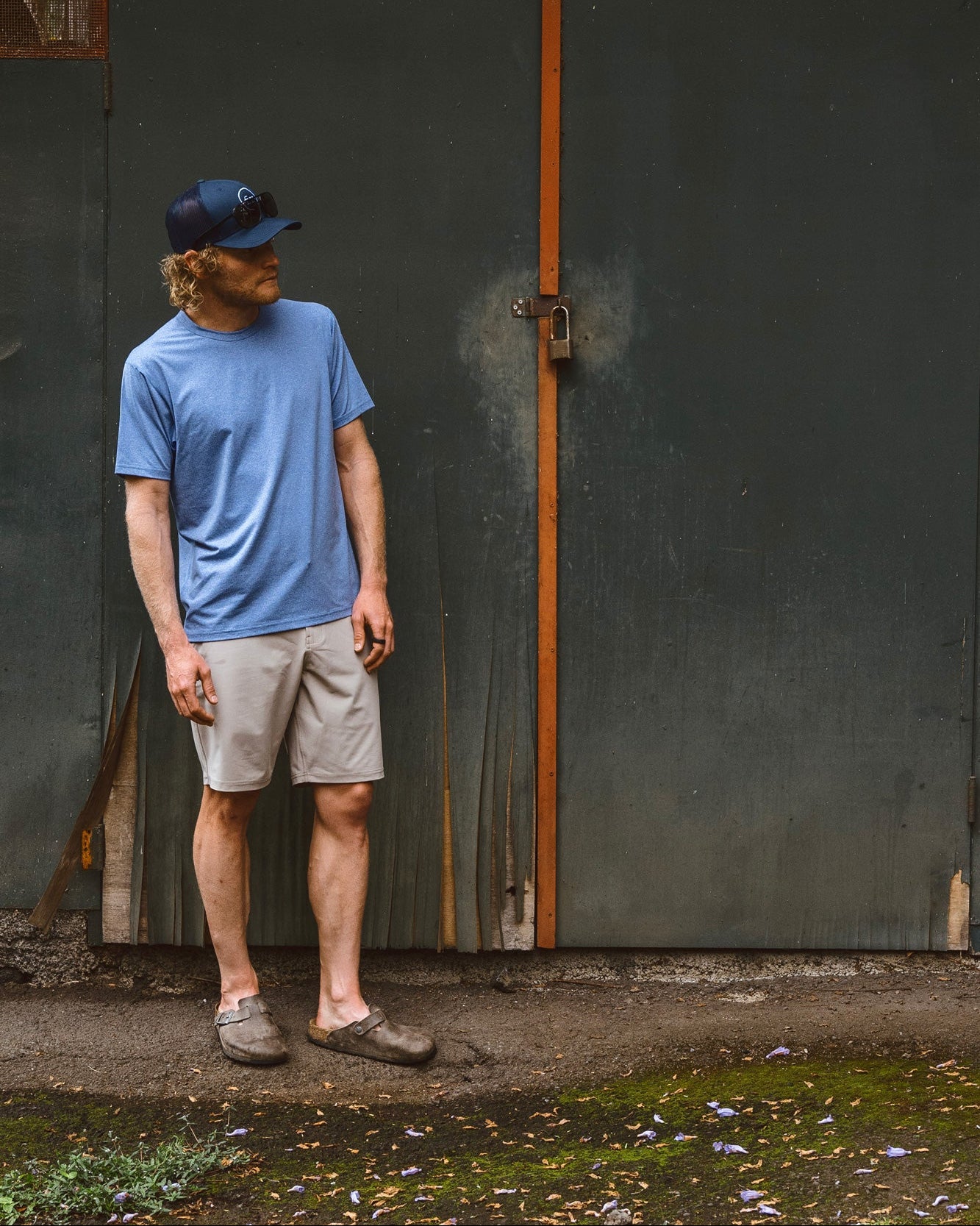 Eric Lagerstrom standing outdoors in front of a rundown wall wearing Foreign Rider Performance Short Sleeve T-shirt