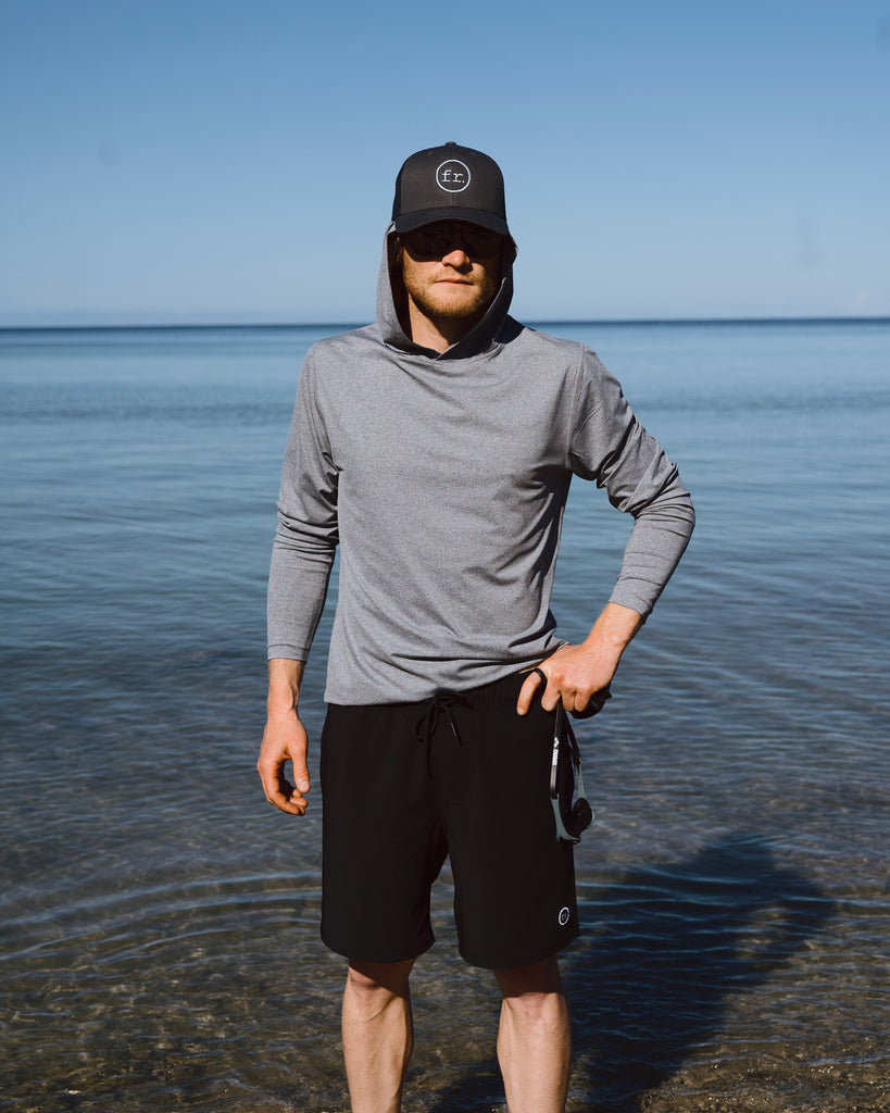 Eric Lagerstrom standing ankle deep in the Pacific Ocean on Hawaii Island wearing Foreign Rider FR. Utility Boardshorts