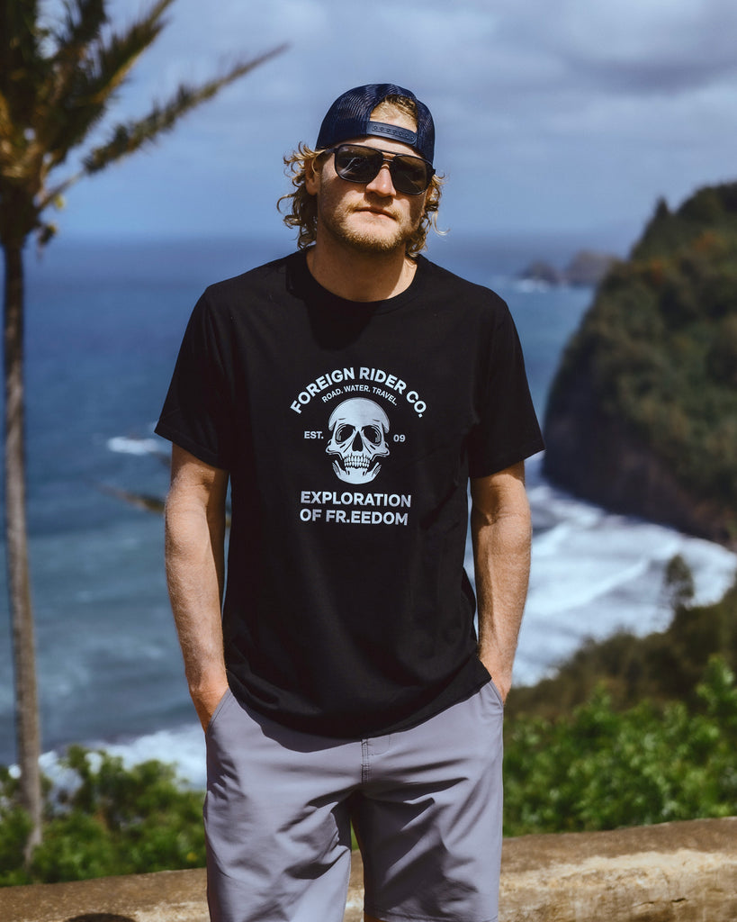 Eric Lagerstrom standing on a Hawaii Island cliff over the Pacific ocean wearing Foreign Rider clothing