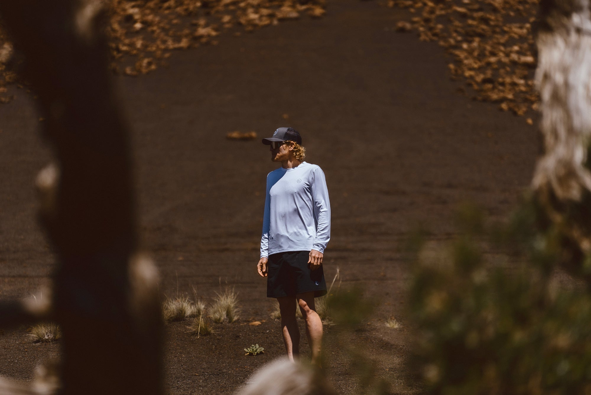Eric Lagerstrom standing in barren Hawaii Island landscape wearing Foreign Rider apparel