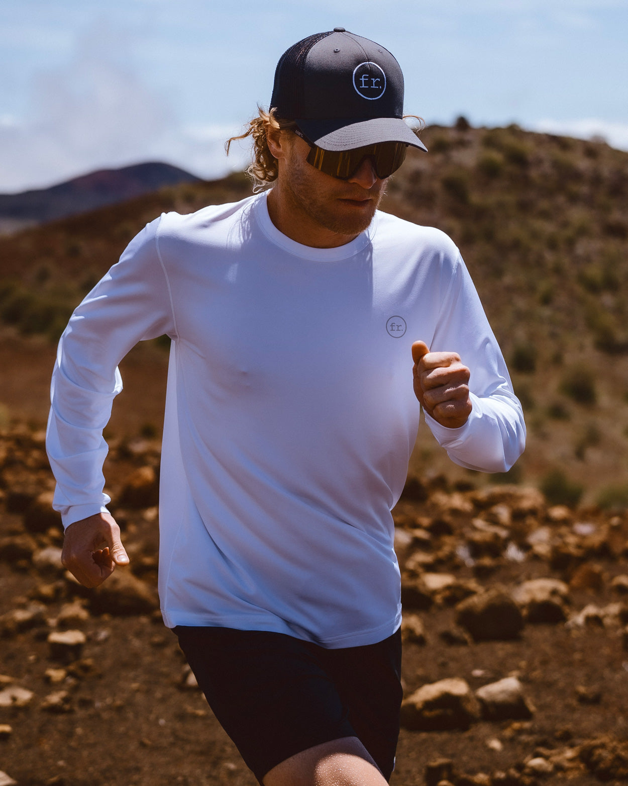 Eric Lagerstrom running on Hawaii Island rocky landscape wearing Foreign Rider apparel