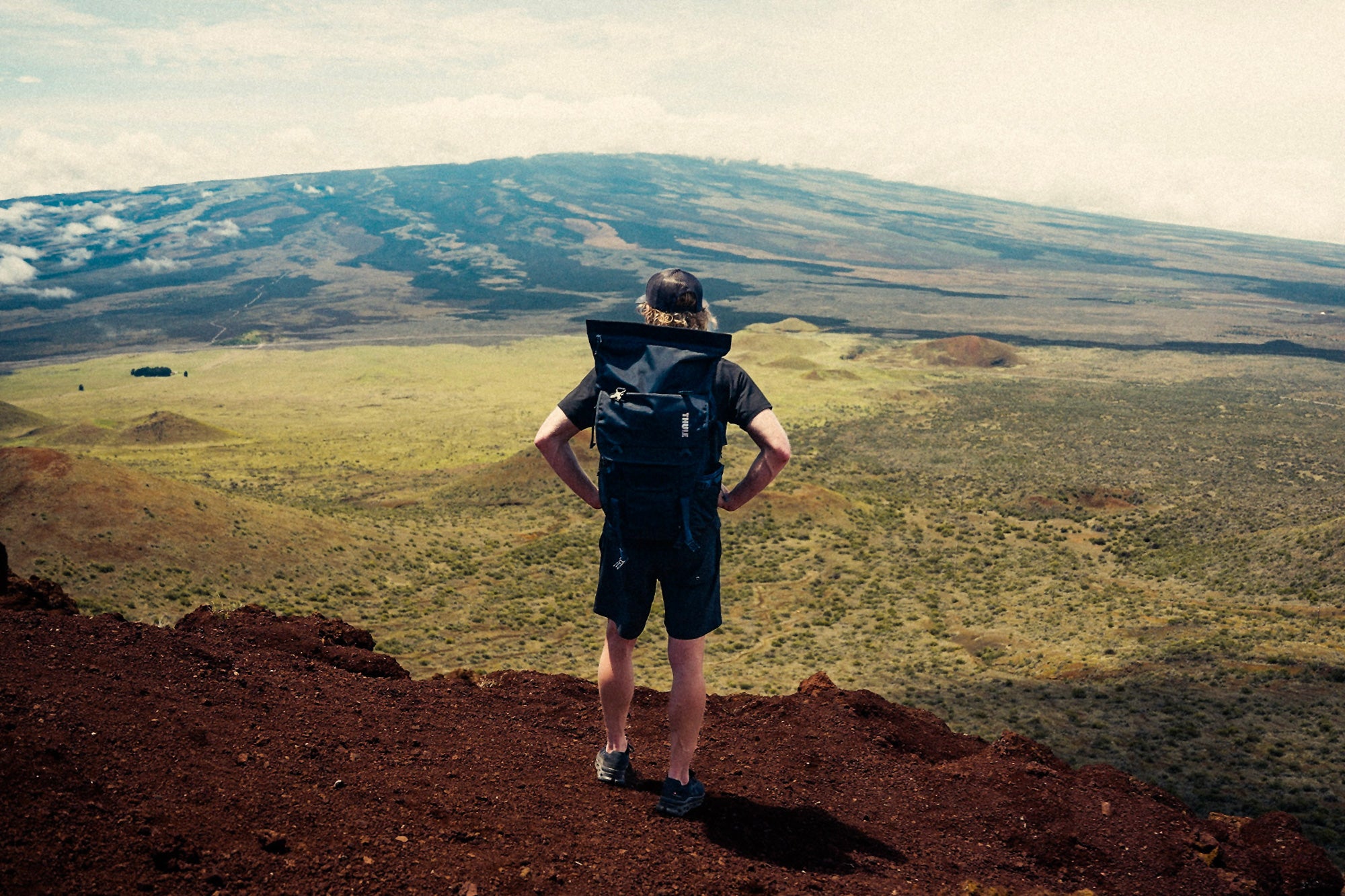 Eric Lagerstrom standing on a cliff overlooking barren Hawaii Island landscape